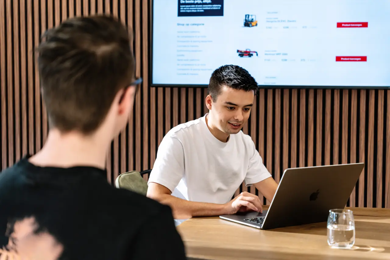 Professioneel teamoverleg met laptop en presentatie, illustratie van samenwerking en huisstijl.